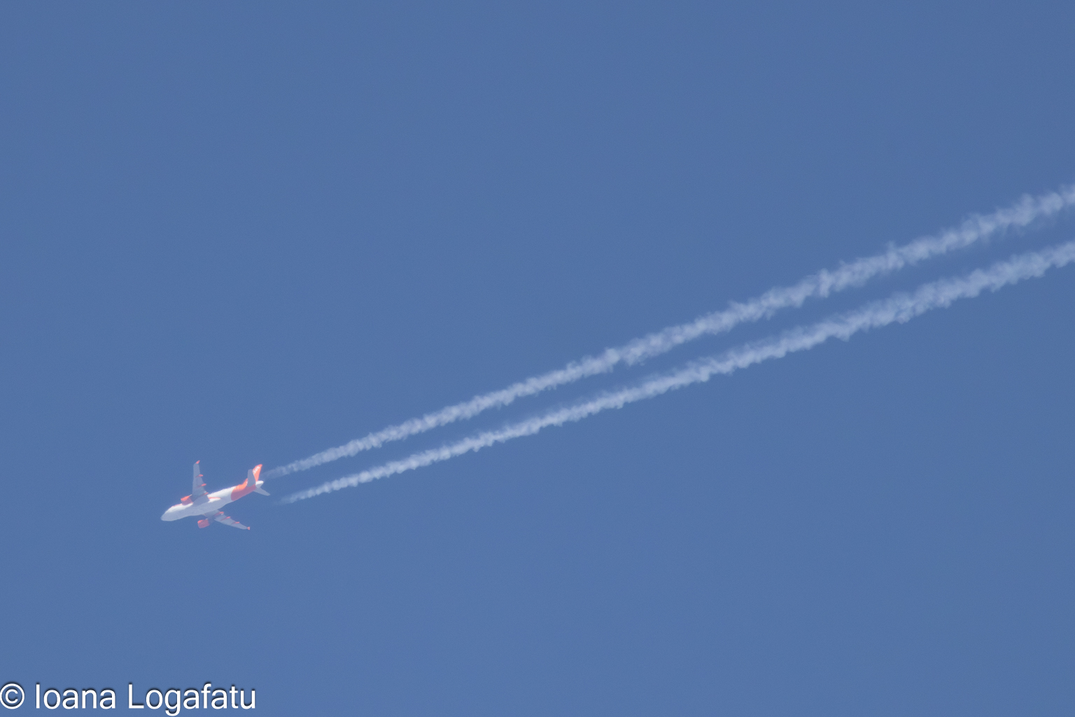 Airplane soaring through a clear blue sky above